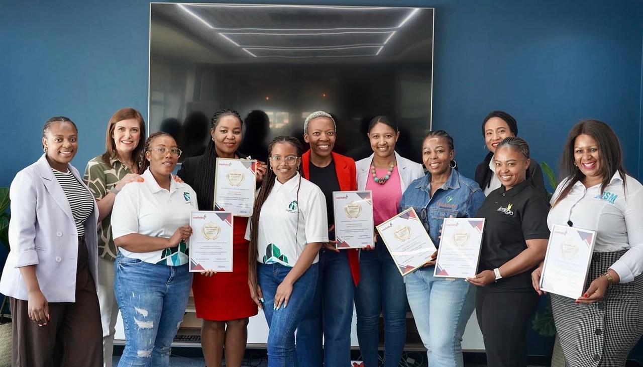 Wooden shelf with gray and olive drab green baseball caps, next to wooden clothes hanger with sweaters.